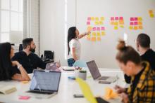 Young woman placing sticky notes on wall